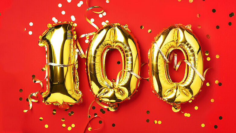 Gold foil balloon number, digit one hundred. Birthday greeting card with inscription 100. Anniversary celebration event. Banner. Golden numeral, red background. Numerical digit, light bokeh, glitter Gold foil balloon number, digit one hundred. Birthday greeting card with inscription 100. Anniversary celebration event. Banner. Golden numeral, red background. Numerical digit, light bokeh, glitter