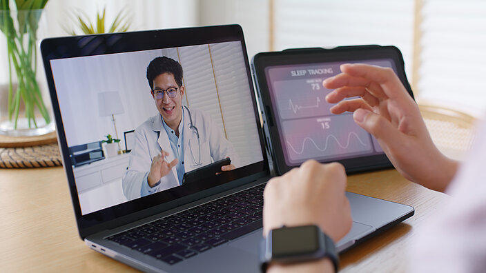 Telemedzinische Betreuung durch einen Arzt, der über einen Laptop dazugeschaltet ist. 