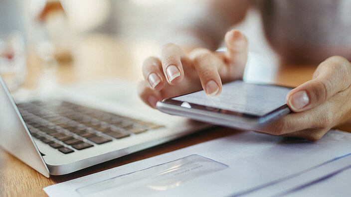 Journalist arbeitet an Laptop und Smartphone