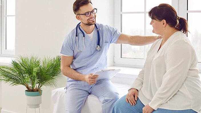 Overweight woman having consultation at doctor's office during medical examination in clinic.