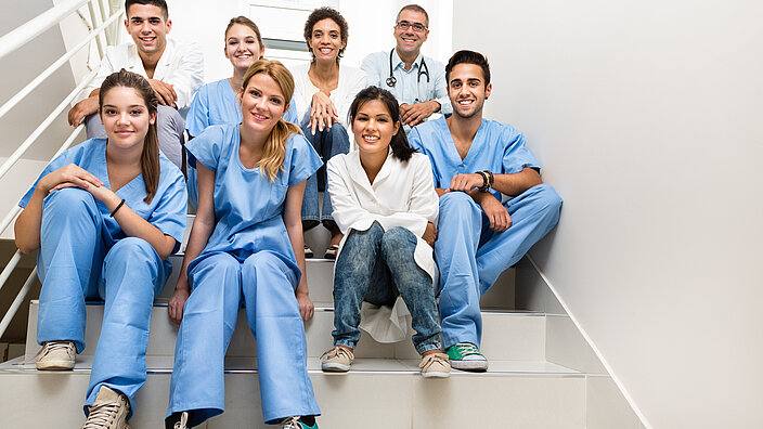 Medizinisches Team sitzt auf Kliniktreppe